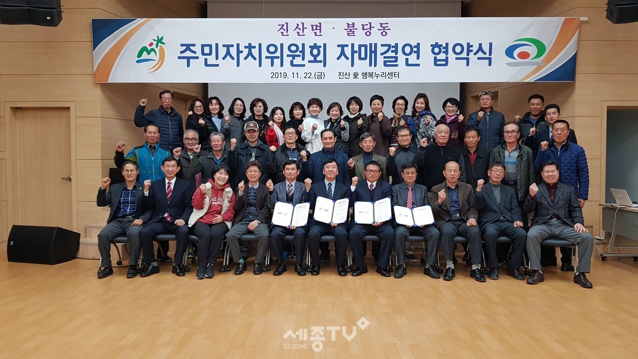 22일 진산愛행복누리센터에서 진산면과 불당동 주민자치위원회 회원들과 관계자들이 협약을 맺고 기념사진을 찍고 있다.(사진제공=금산군청)