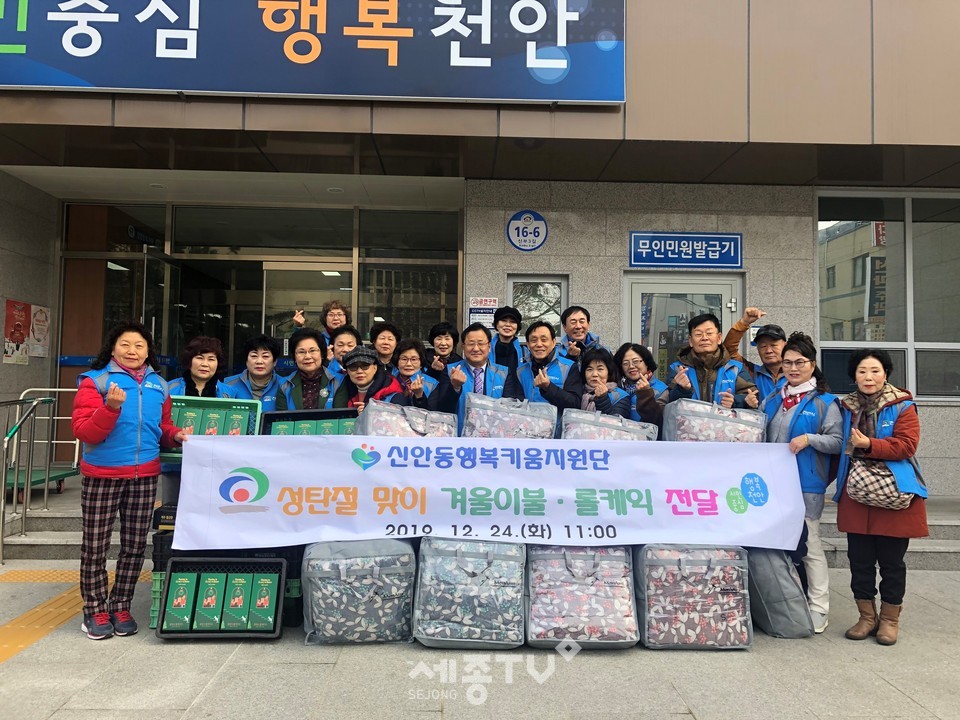 천안시 신안동 행복키움지원단이 24일 성탄절을 맞아 관내 홀로 사는 노인과 저소득 100가구에 극세사 겨울이불과 롤케이크를 전달하며 기념사진을 찍고 있다.(사진제공=천안시청)