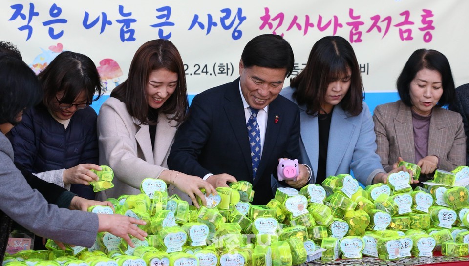 24일 구청 1층 로비에서 열린 천사 나눔저금통 기탁식에서 황인호 동구청장(사진 왼쪽에서 네 번째)과 이나영 동구의회 의장(사진 왼쪽에서 6번째)이 천사 나눔저금통을 개봉하고 있다.(사진제공=대전 동구청)