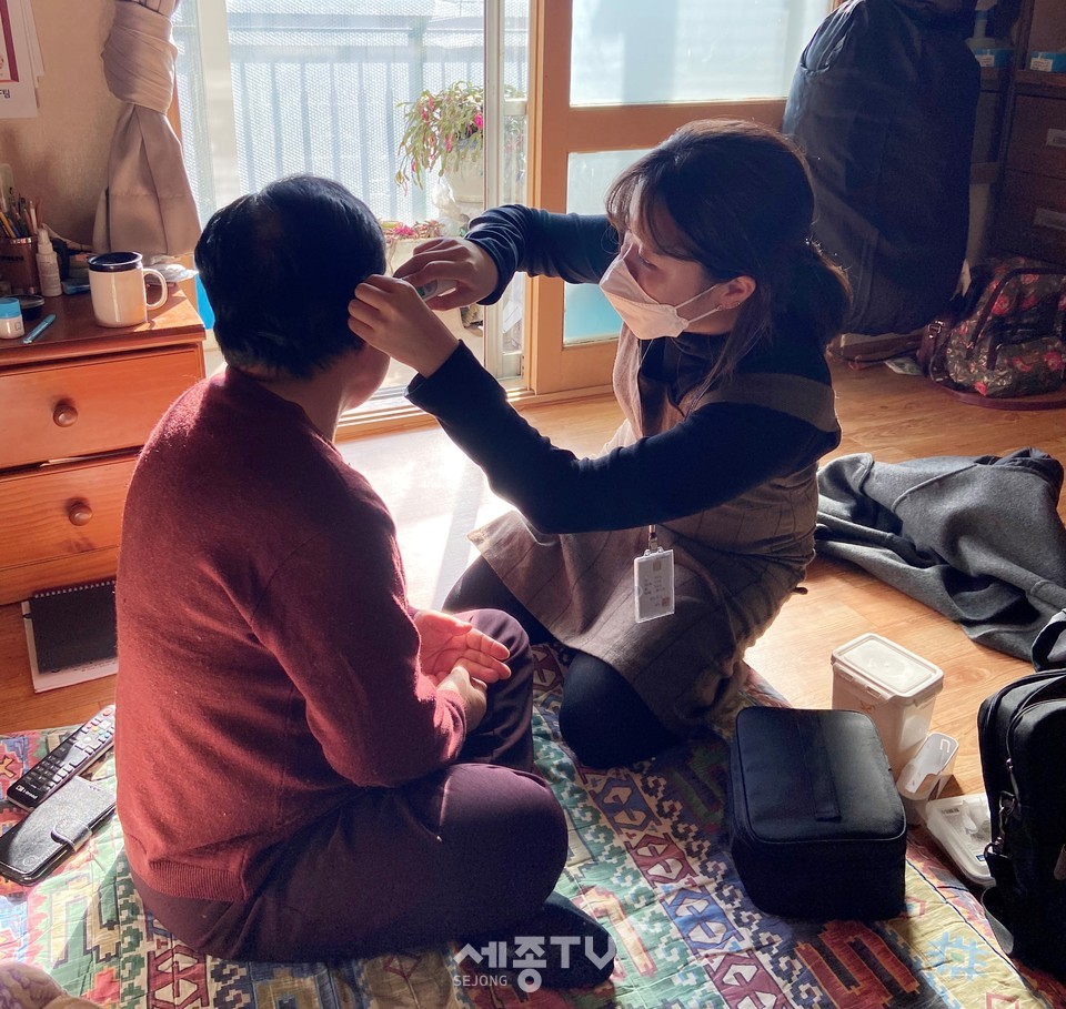 성정2동 맞춤형복지팀 간호직 주무관이 지역사회 통합돌봄 대상자 집에서 방문건강관리서비스로 체온을 측정하고 있다. (사진제공=천안시청)