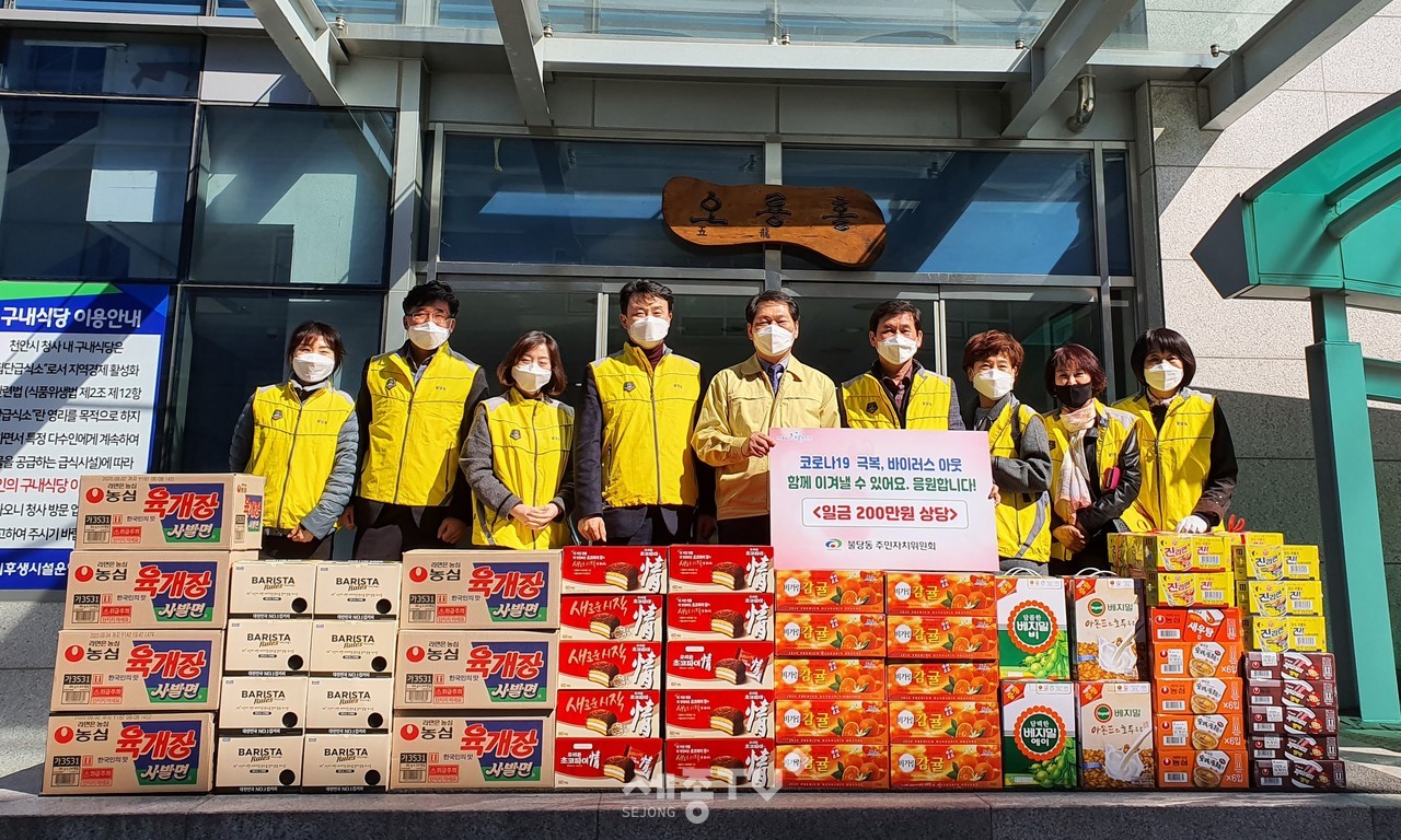 천안시 불당동 주민자치위원회가 11일 코로나19 확산 방지 및 극복을 위해 장기간 고된 업무를 수행중인 천안시에 격려물품을 전달하고 기념사진을 촬영하고 있다. (사진제공=천안시청)