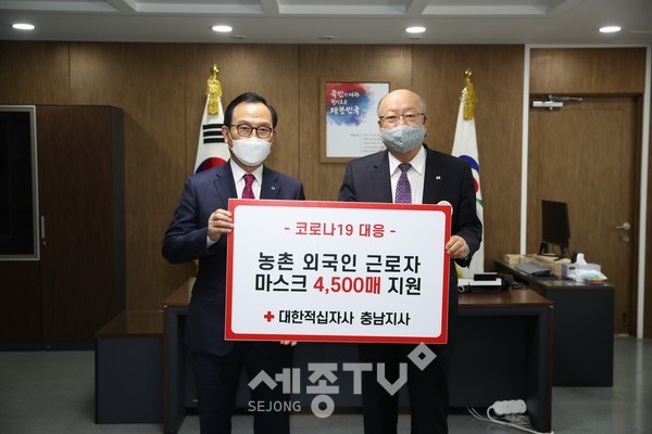 지난 20일 대한적십자사 충남지사가 농업분야 외국인 근로자를 위한 마스크 4500매를 천안시에 기증해 박상돈 시장(왼쪽)과 유창기 회장(오른쪽)이 기념사진을 촬영하고 있다. (사진제공=천안시청)