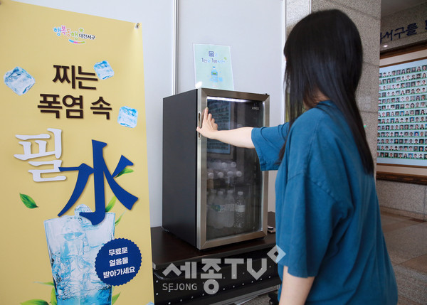 서구청을 방문한 주민이 1층 로비에서 설치된 냉장고에서 얼음물을 꺼내고 있다.