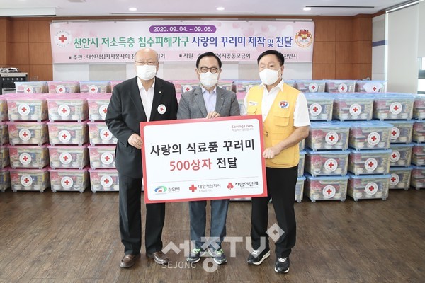 대한적십자봉사회 천안지구협의회가 충남사회복지공동모금회의 지원을 받아 이뤄진 천안시 저소득층 침수피해가구 사랑의 꾸러미 제작 및 전달 행사에서 천안시와 봉사단체가 지난 8일 식료품과 생필품 등을 담은 ‘사랑의 꾸러미’를 500개 침수피해가구에 전달했다. (왼쪽부터 유창기 대한적십자사 충남지사 회장, 박상돈 천안시장, 이은상 대한적십자사봉사회 천안지구협의회 회장) 사진제공=천안시청