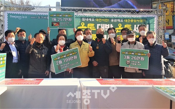 지난달 14일 중앙시장 화월통 입구에서 진행된 ‘동구애(愛) 써유~ 온통세일’ 중앙시장활성화구역 경품 추첨행사에 참석한 황인호 동구청장(앞줄 가운데)과 상인회장들 모습.(사진제공=동구청)