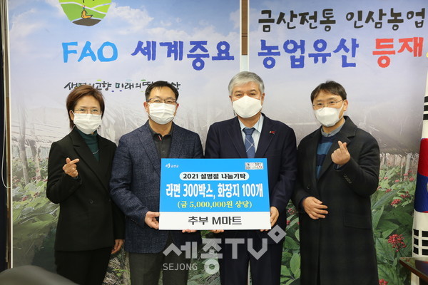 추부 M마트 강포구 대표(왼쪽 두 번째)가 물품기탁을 하고 문정우 금산군수(오른쪽 두 번째)와 기념사진을 찍고 있다.(사진제공=금산군청)