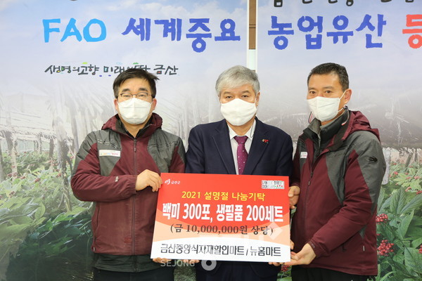 금산중앙식재재할인마트 조채연 대표(왼쪽)가 이웃 돕기 물품 기탁 후 문정우 금산군수(가운데)와 기념사진을 찍고 있다.(사진제공=금산군청)