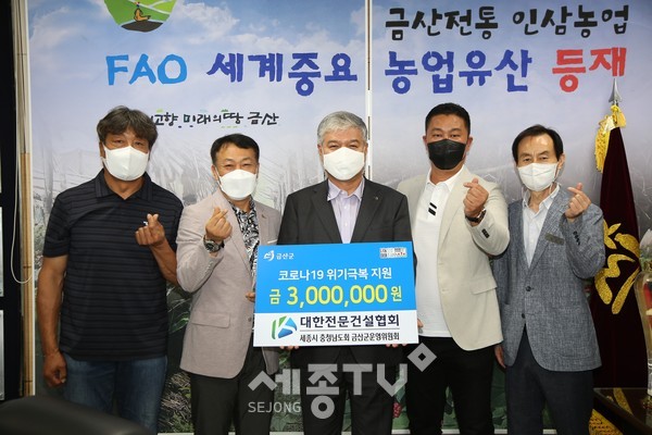 대한전문건설협회 금산군운영위원회 김도연 회장(왼쪽 두 번째)이 성금을 전달하고 문정우 금산군수와 기념사진을 찍고 있다.