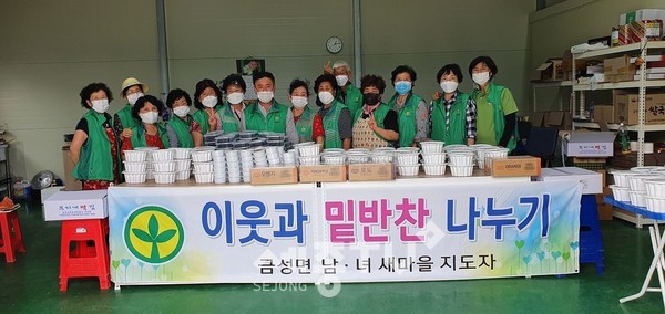 금성면새마을부녀회 회원들이 밑반찬 나눔 봉사에 나서며 기념사진을 찍고 있다.