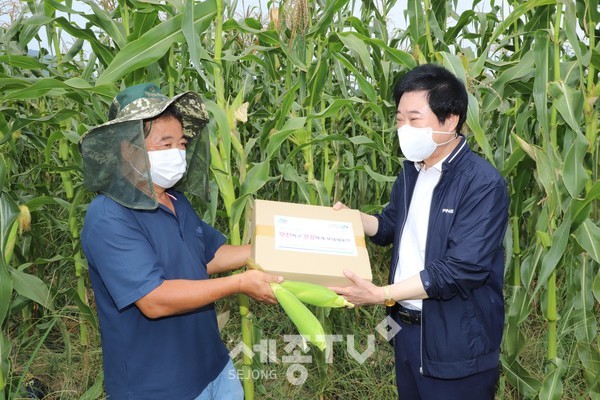 서정훈 홍성농협상임이사(오른쪽)가 무더위로 지친 농업인을 찾아 식염포도당, 얼음스카프 등으로 구성된 폭염키트를 전달하고 있다.
