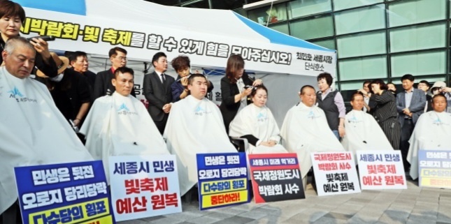 사진설명=세종시의회 국민의 힘 소속 시의원 7명 전원이 8일 최민호 세종시장의 단식현장 앞에서  민주당 시의원들의 예산 삭감 행태를 비판하고 즉각적인 예산 반영을 요구하며 삭발식을 갖고 있는 장면