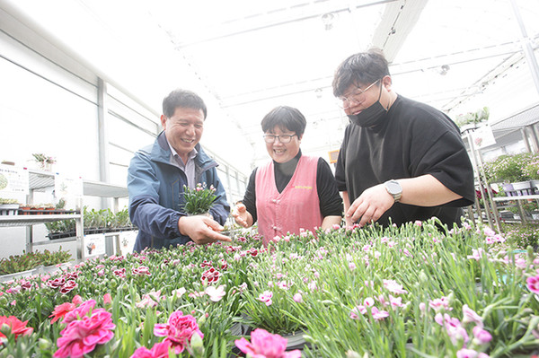 사진1_▲김덕환 천안시산림조합장이 나무시장을 찾은 손님에게 직접 나무를 고르는 방법과 나무의 수종에 대해 설명하고 있다.
