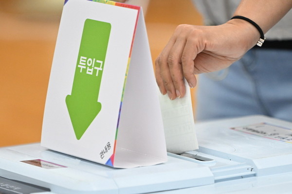 제21대 대선 사전투표 첫날인 29일 오전 광주 동구 지원2동 행정복지센터에 마련된 사전투표소에서 한 유권자가 투표 용지를 투표함에 넣고 있다.
