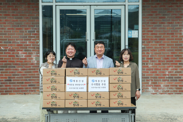 계룡건설 진중길 상무(오른쪽에서 두 번째)가 청소년사회복지시설 효광원 김현 원장(왼쪽에서 두 번째)에게 위문품을 전달하고 관계자들과 기념 촬영을 하고 있다./사진제공=계룡건설